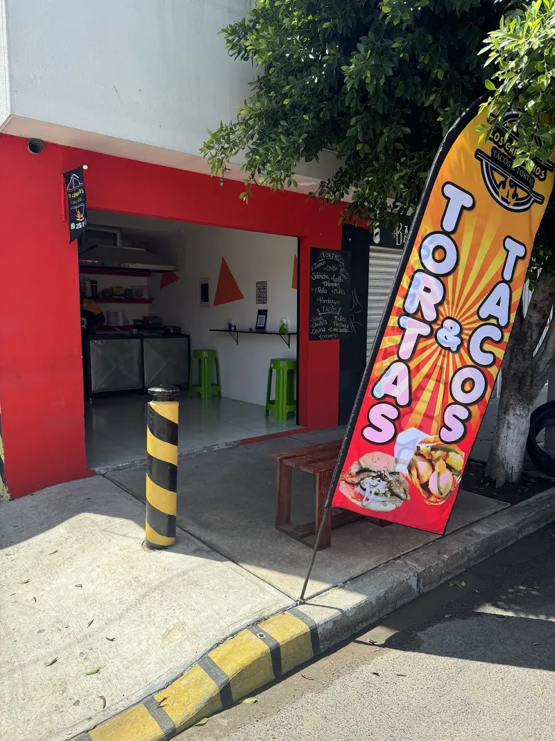 Fachada roja del local de Los Capiruchos con su banderín de Tacos y Tortas